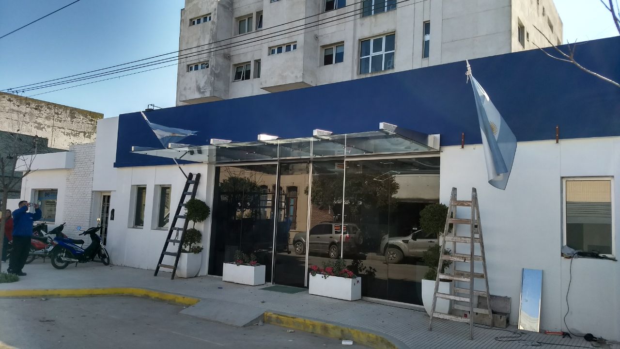 Concesionaria con frente vidriado y marquesina de vidrio
